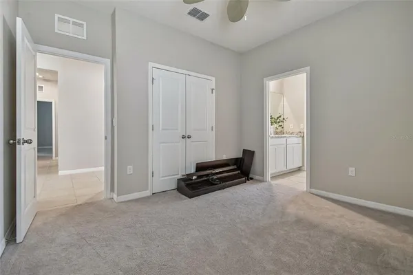 an empty room with windows and ceiling fan