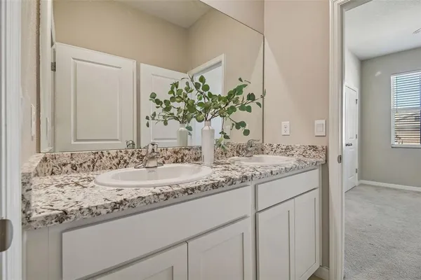 a bathroom with a granite countertop sink and a mirror