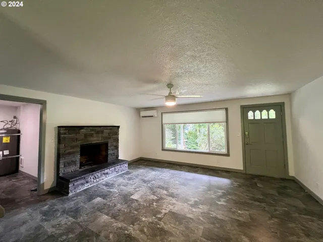 an empty room with windows and fireplace