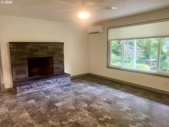 an empty room with windows and fireplace
