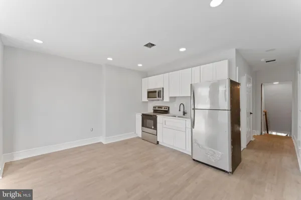 a kitchen with refrigerator cabinets and wooden floor