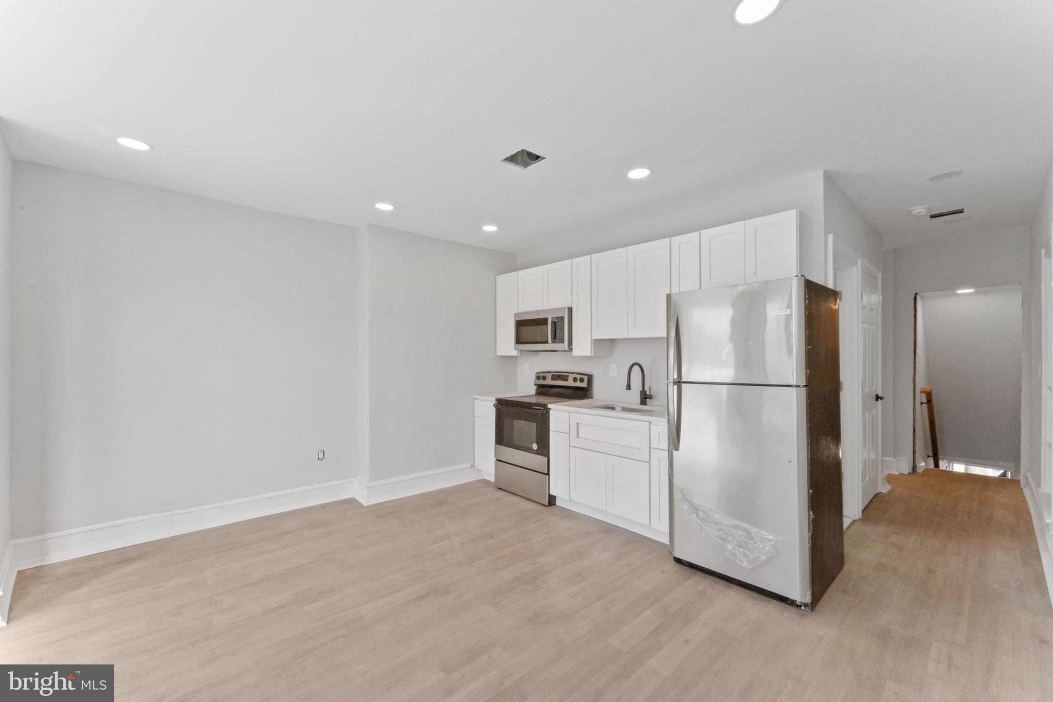 7703 Ridge Avenue Philadelphia, PA 19128 - Photo 6 of 14 a kitchen with refrigerator cabinets and wooden floor