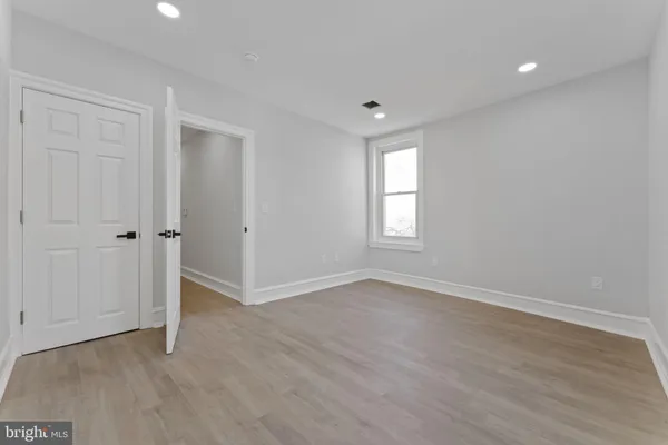 an empty room with wooden floor and window