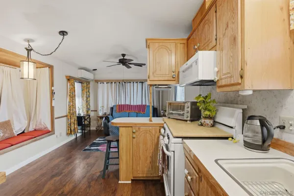 a view of a kitchen area with furniture and wooden floor