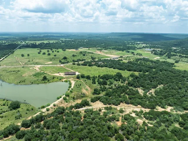 an aerial view of ocean with residential houses with outdoor space and trees