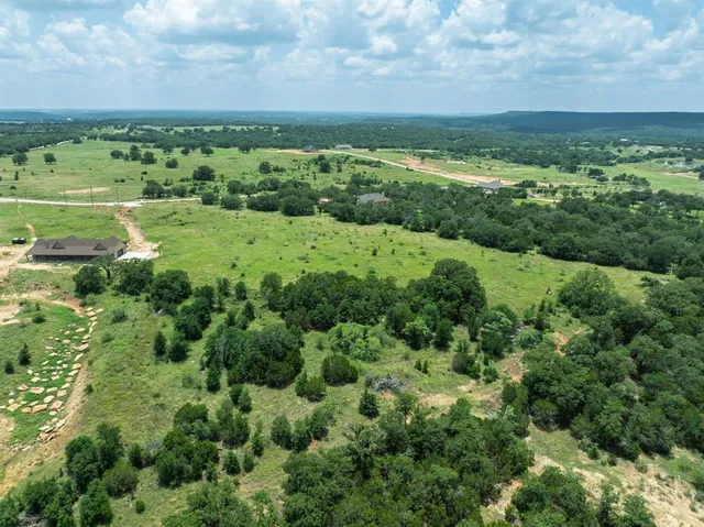 a view of a green field with houses in the background