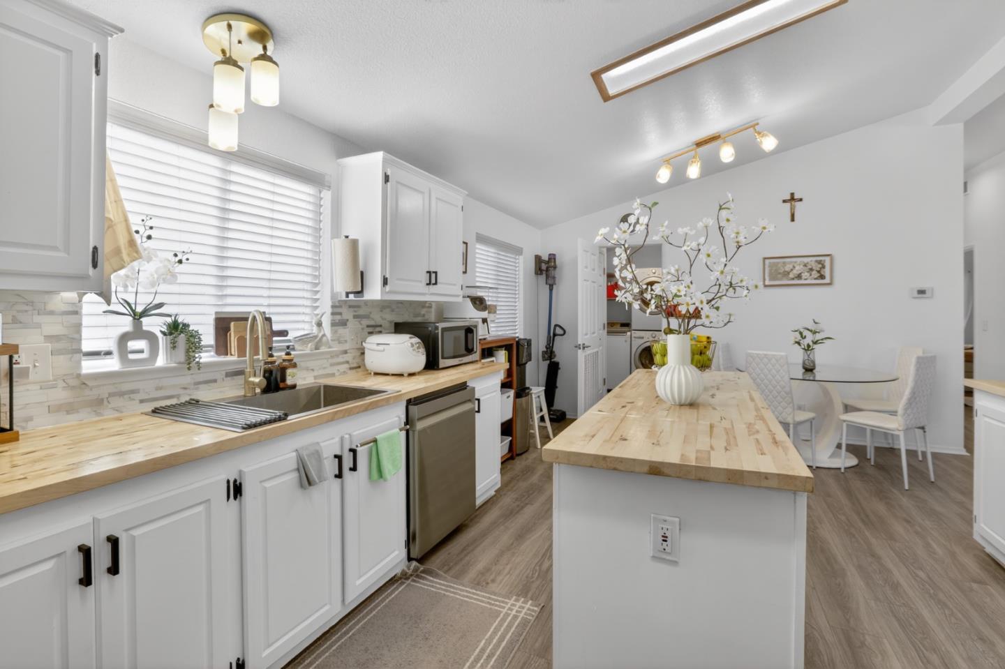 120 Dixon Landing Road, Unit 9 Milpitas, CA 95035 - Photo 16 of 34 a kitchen with a sink dishwasher a stove a dining table and chairs with wooden floor