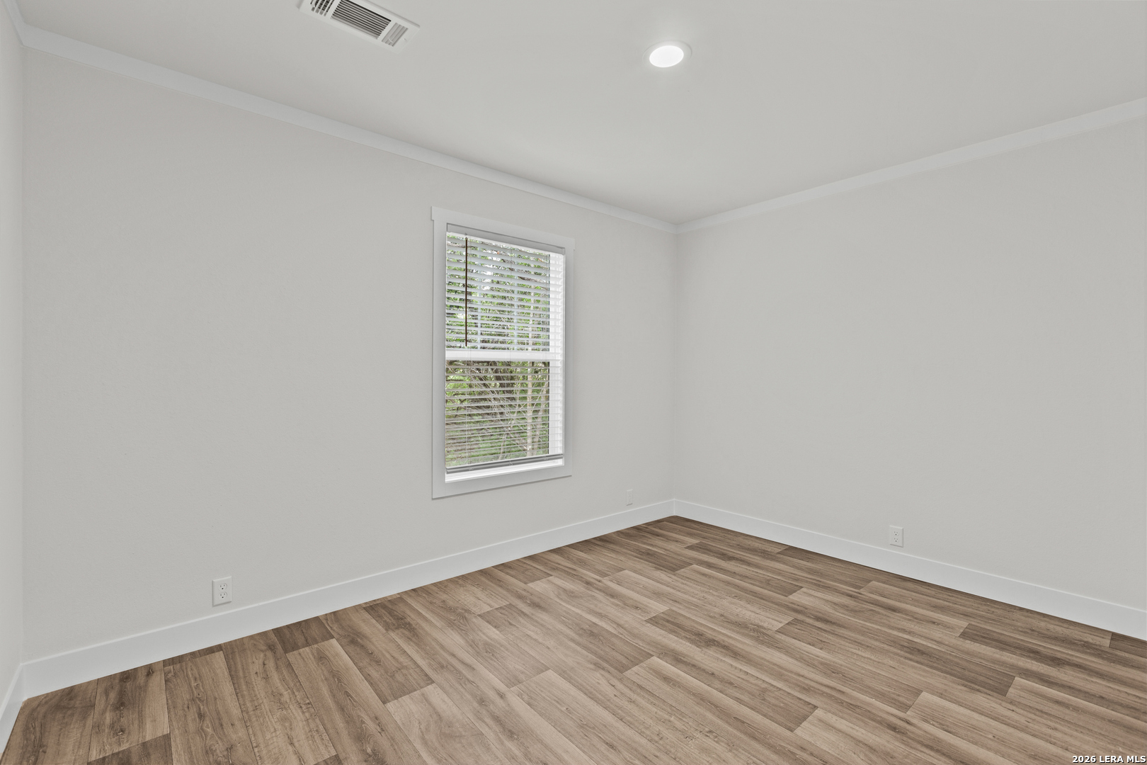 697 County Road 664 Devine, TX 78016 - Photo 11 of 19 an empty room with wooden floor and windows