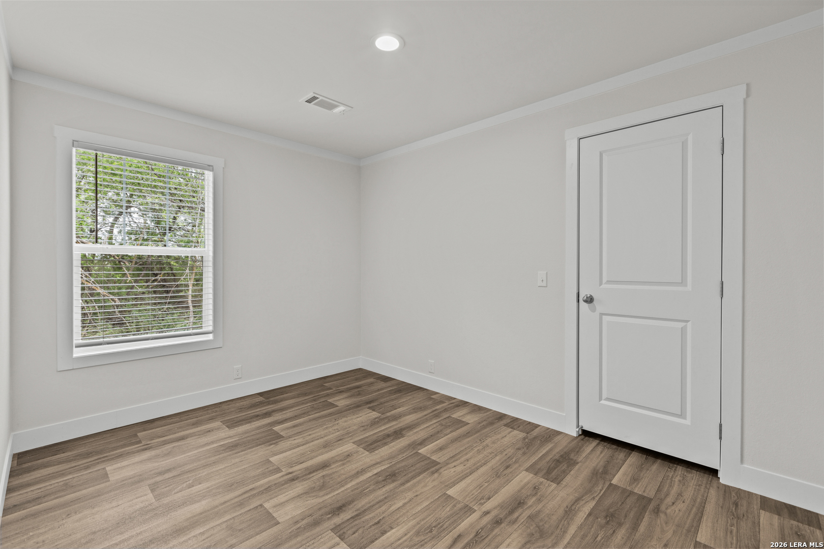 697 County Road 664 Devine, TX 78016 - Photo 12 of 19 an empty room with wooden floor and windows