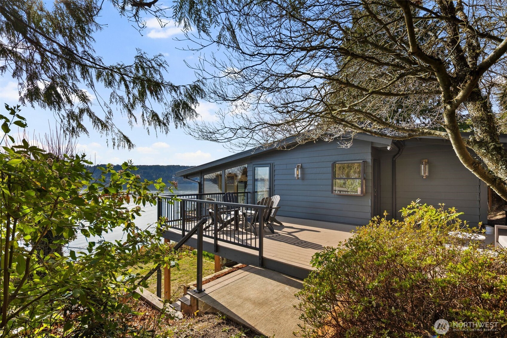 28605 Manzanita Beach Road Southwest Vashon, WA 98070 - Photo 4 of 39 a backyard of a house with table and chairs under an umbrella