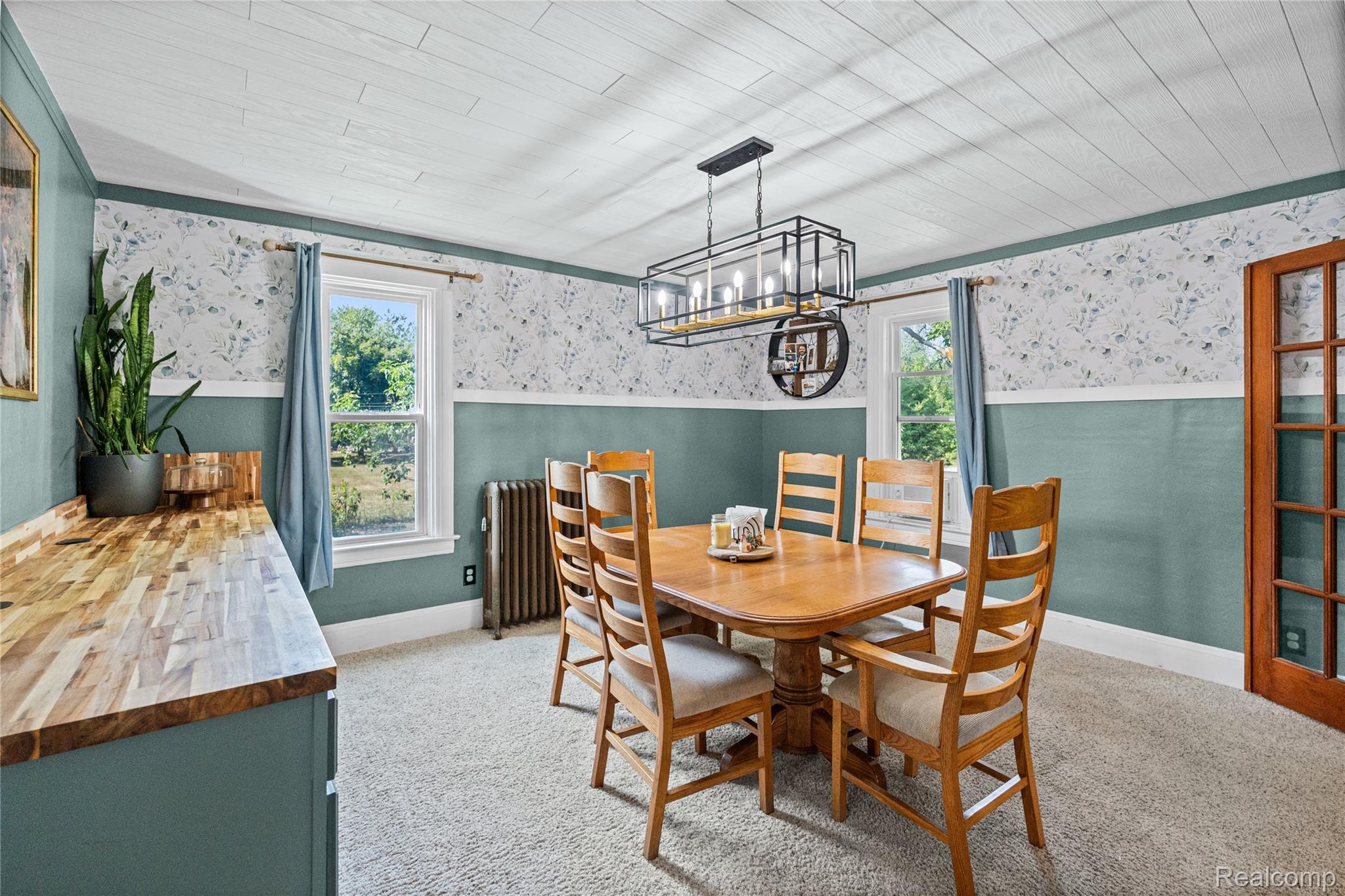 1175 South Morrish Road Flint, MI 48532 - Photo 18 of 72 Dining area featuring a linear chandelier, wood-finish flooring, two windows, wainscoting, and a paneled ceiling