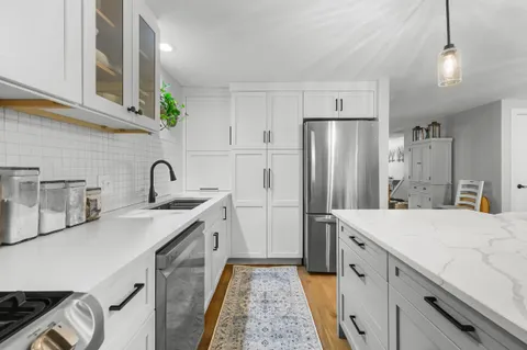 a kitchen with stainless steel appliances a refrigerator sink and cabinets