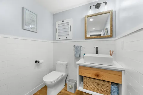 a bathroom with a toilet sink and mirror