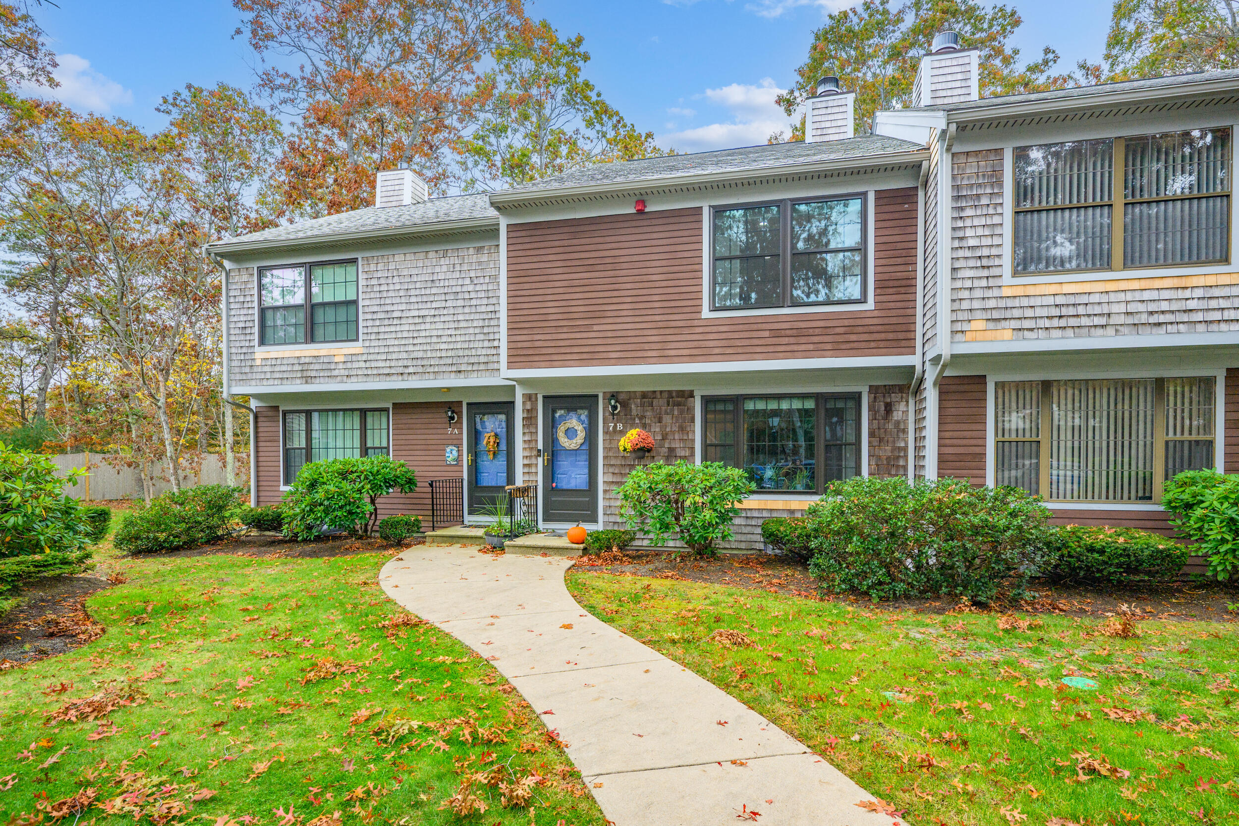 195 Falmouth Road, Unit 7B Mashpee, MA 02649 - Photo 2 of 38 a front view of a house with garden and porch