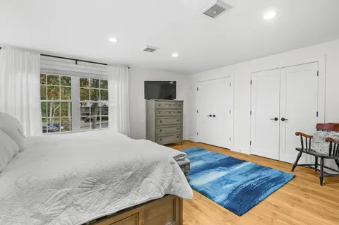 a bedroom with a bed closet and a large window