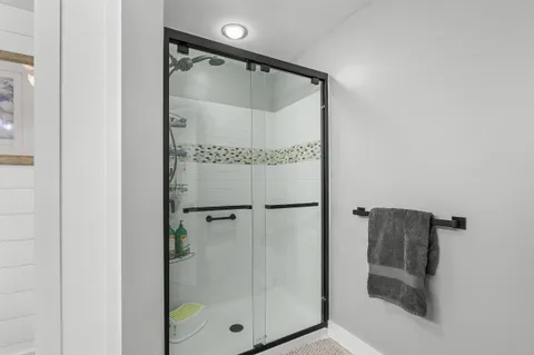 a bathroom with a glass shower door and a mirror