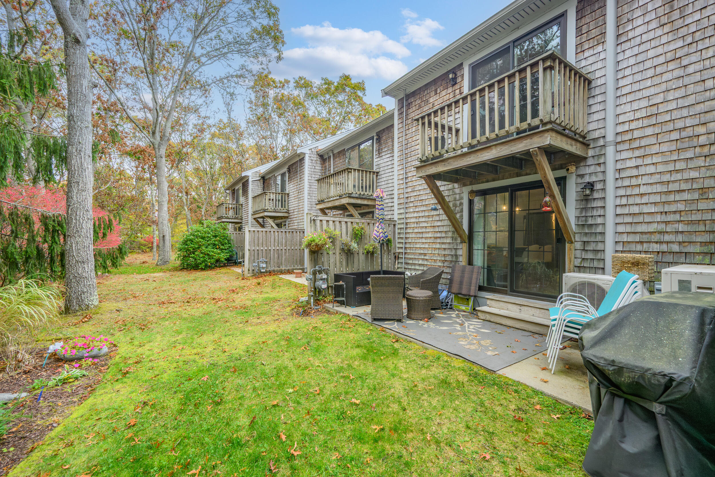 195 Falmouth Road, Unit 7B Mashpee, MA 02649 - Photo 33 of 38 a view of a house with backyard and sitting area