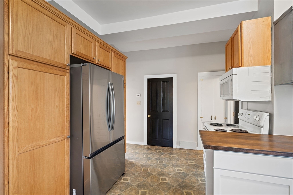 169 Main Street Acton, MA 01720 - Photo 11 of 39 a kitchen with stainless steel appliances granite countertop a refrigerator and a sink