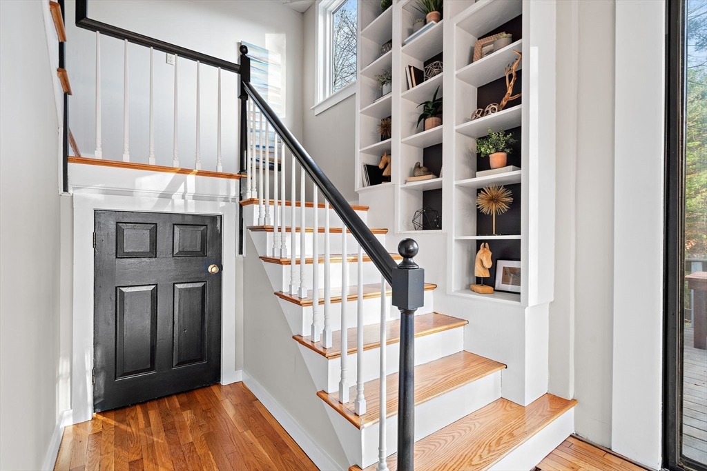 169 Main Street Acton, MA 01720 - Photo 21 of 39 a view of staircase with lots of frames on wall and a rug