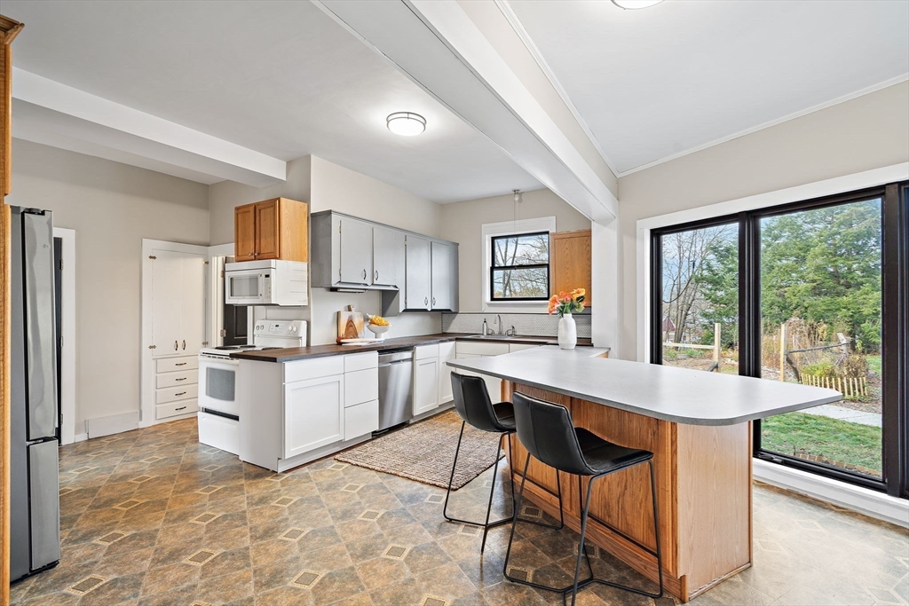 169 Main Street Acton, MA 01720 - Photo 8 of 39 a kitchen with a table chairs microwave and cabinets