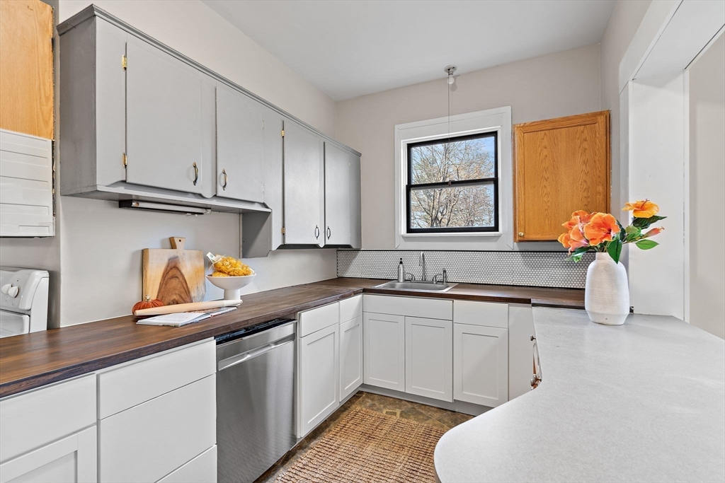 169 Main Street Acton, MA 01720 - Photo 10 of 39 a kitchen with stainless steel appliances granite countertop a sink a window and white cabinets