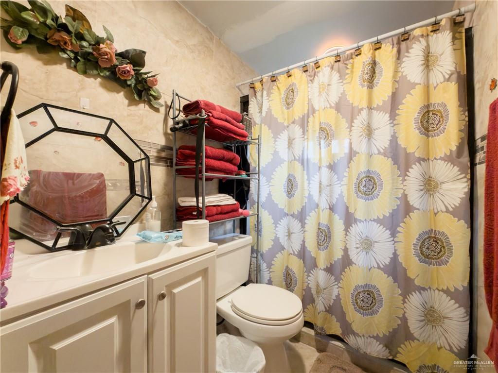 21707 Hidalgo Street Edcouch, TX 78538 - Photo 17 of 27 a bathroom with a sink toilet and shower curtain