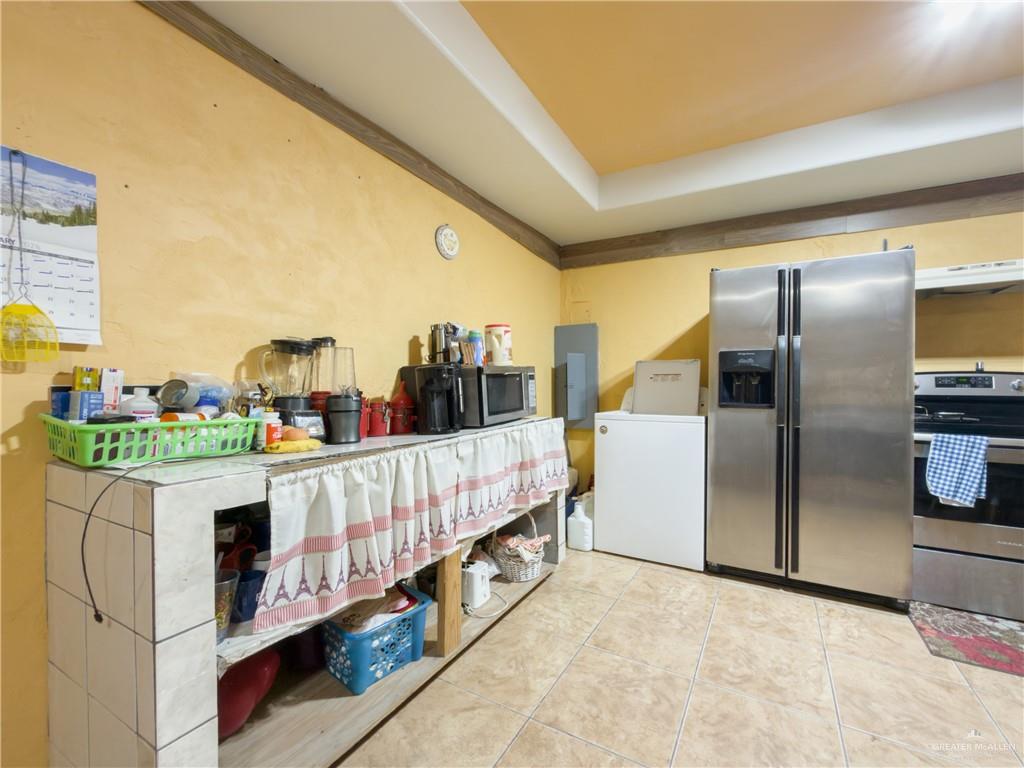 21707 Hidalgo Street Edcouch, TX 78538 - Photo 21 of 27 a kitchen with stainless steel appliances a refrigerator a stove a washer and dryer