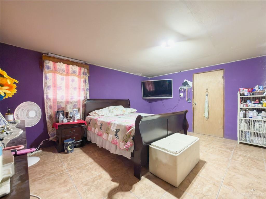 21707 Hidalgo Street Edcouch, TX 78538 - Photo 10 of 27 a bedroom with a bed and a chandelier