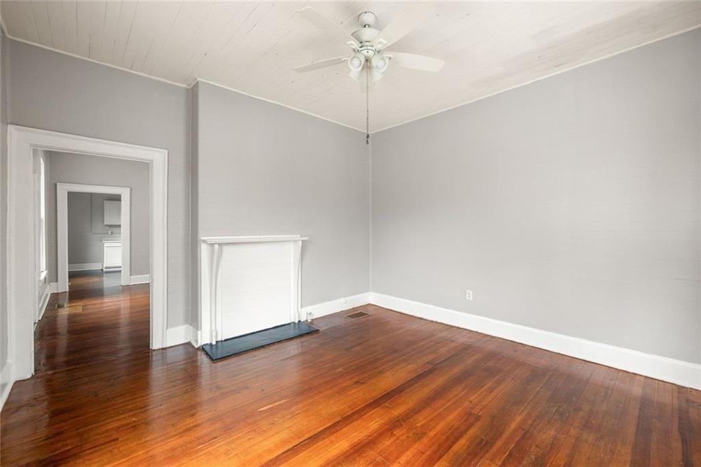 796 Fulton Terrace Southeast Atlanta, GA 30316 - Photo 3 of 35 an empty room with wooden floor chandelier fan and windows