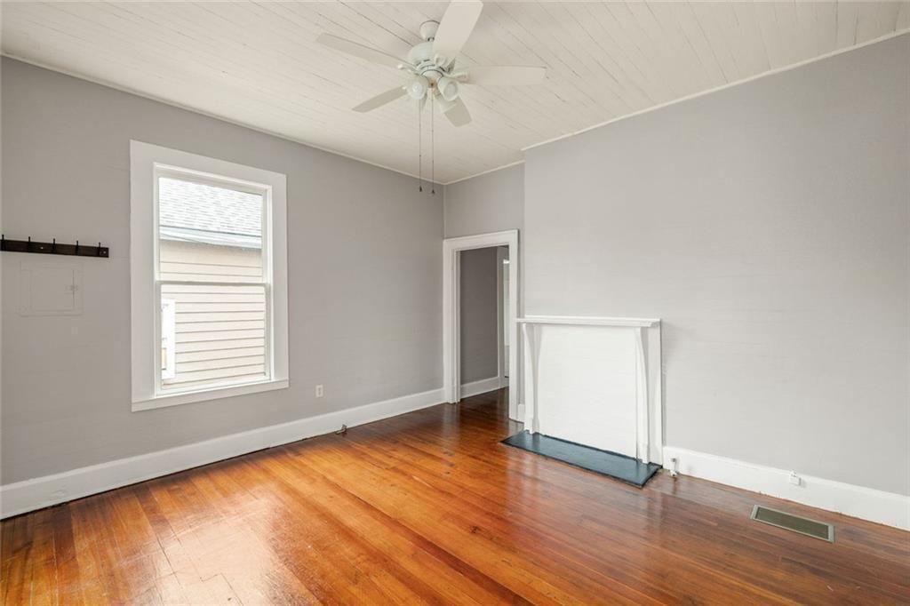 796 Fulton Terrace Southeast Atlanta, GA 30316 - Photo 4 of 35 an empty room with wooden floor chandelier fan and windows