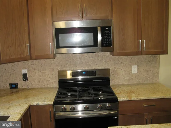 a kitchen with granite countertop stainless steel appliances and cabinets