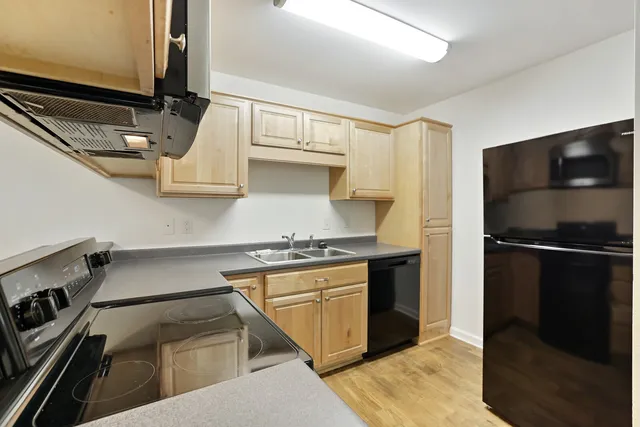 a kitchen with stainless steel appliances granite countertop a refrigerator and a stove