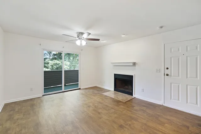 an empty room with windows and fireplace