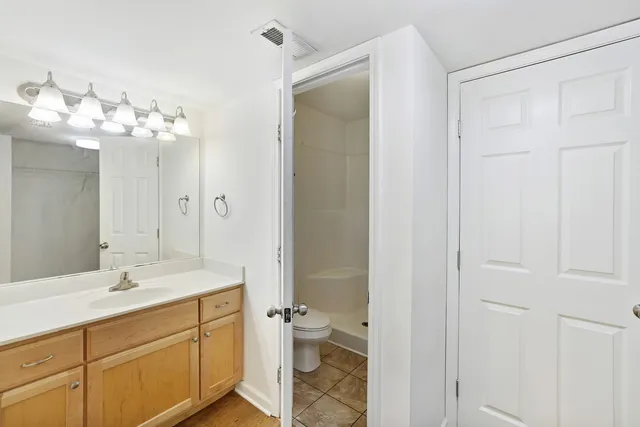 a bathroom with a double vanity sink mirror and a toilet