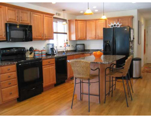 389 Mulpus Road Lunenburg, MA 01462 - Photo 8 of 26 a kitchen with stainless steel appliances granite countertop a stove a refrigerator a sink a dining table and chairs