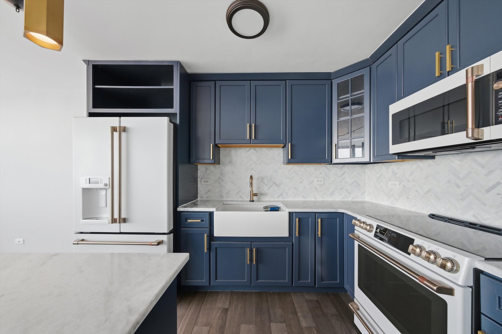 6301 North Sheridan Road, Unit 14G Chicago, IL 60660 - Photo 7 of 22 a kitchen with stainless steel appliances a stove a microwave and white cabinets