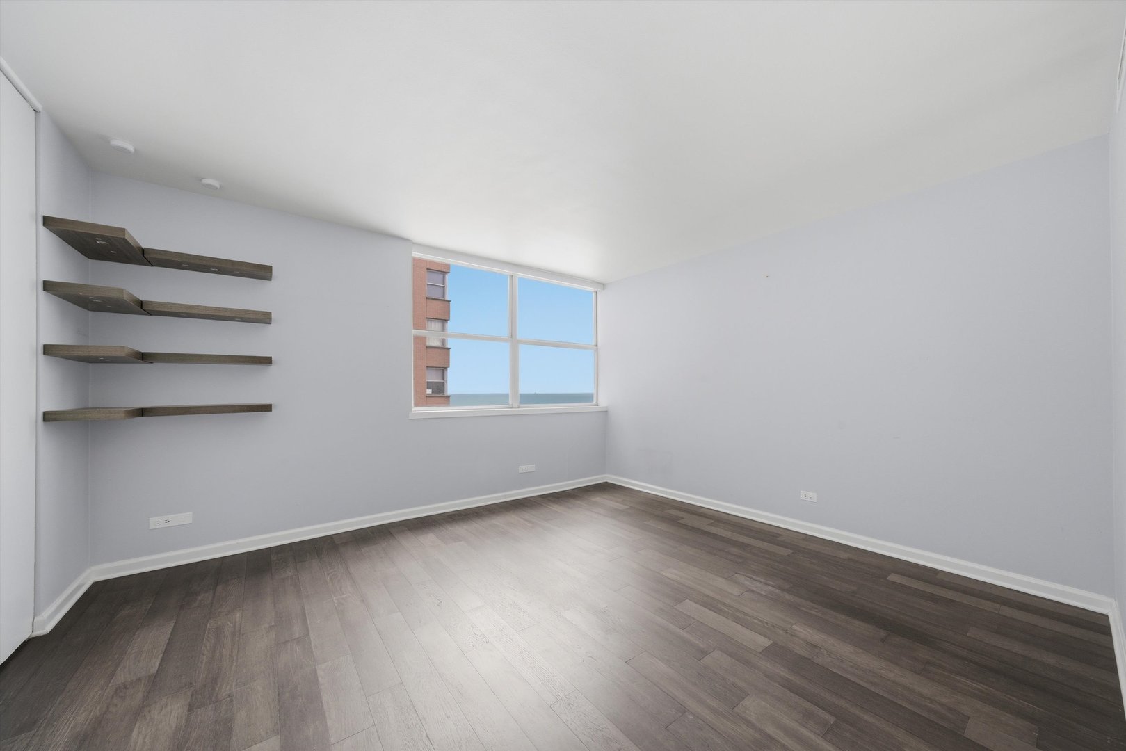 6301 North Sheridan Road, Unit 14G Chicago, IL 60660 - Photo 10 of 22 a view of an empty room with wooden floor and a window