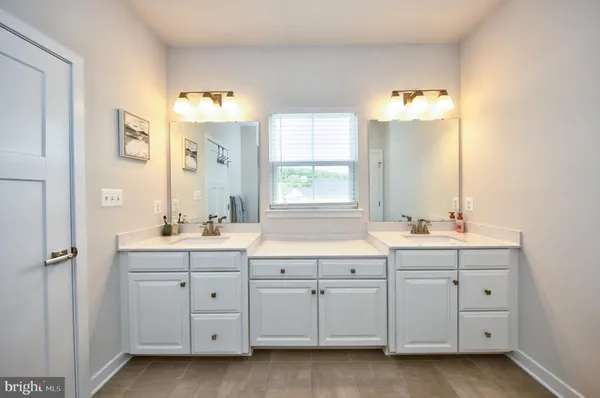 a bathroom with a granite countertop sink double and mirror