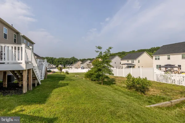 a view of a house with a big yard and large trees