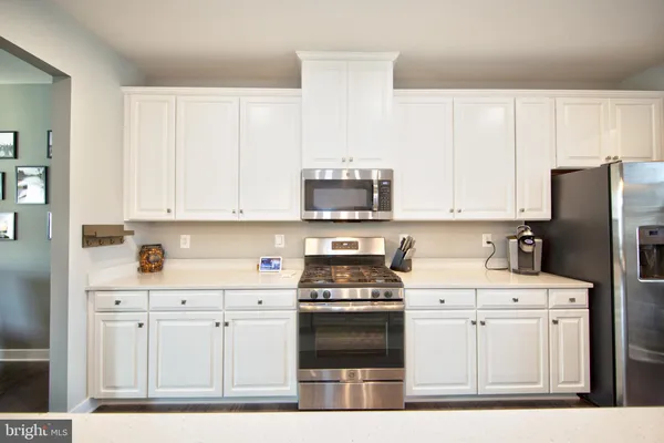 a kitchen with cabinets stainless steel appliances and sink
