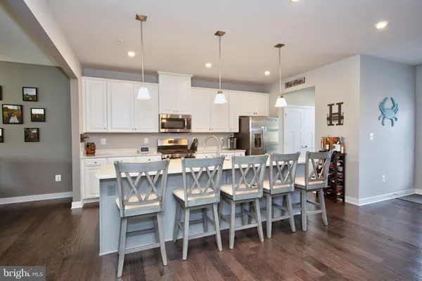 a view of a dining room with furniture wooden floor and kitchen view