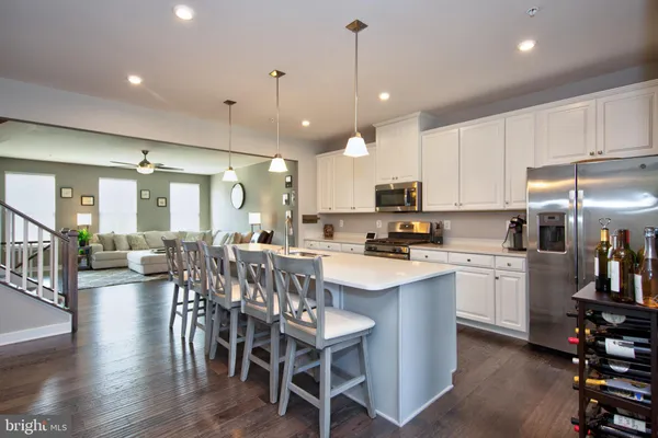 a kitchen with kitchen island granite countertop a center island a sink a stove a dining table and chairs
