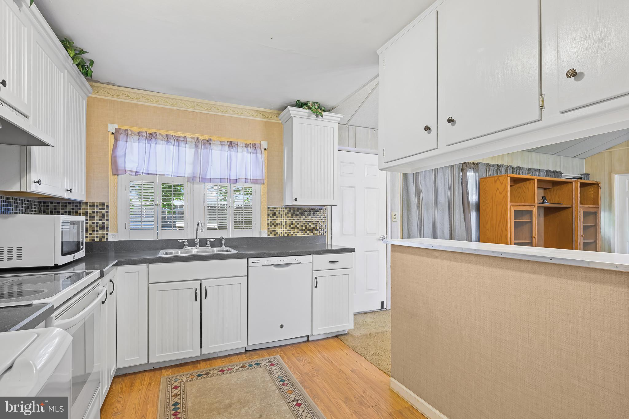 8 Augusta Drive Newark, DE 19713 - Photo 7 of 23 a kitchen with granite countertop white cabinets and white appliances