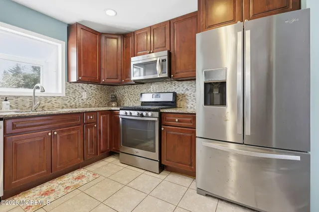 a kitchen with granite countertop a refrigerator and a stove top oven