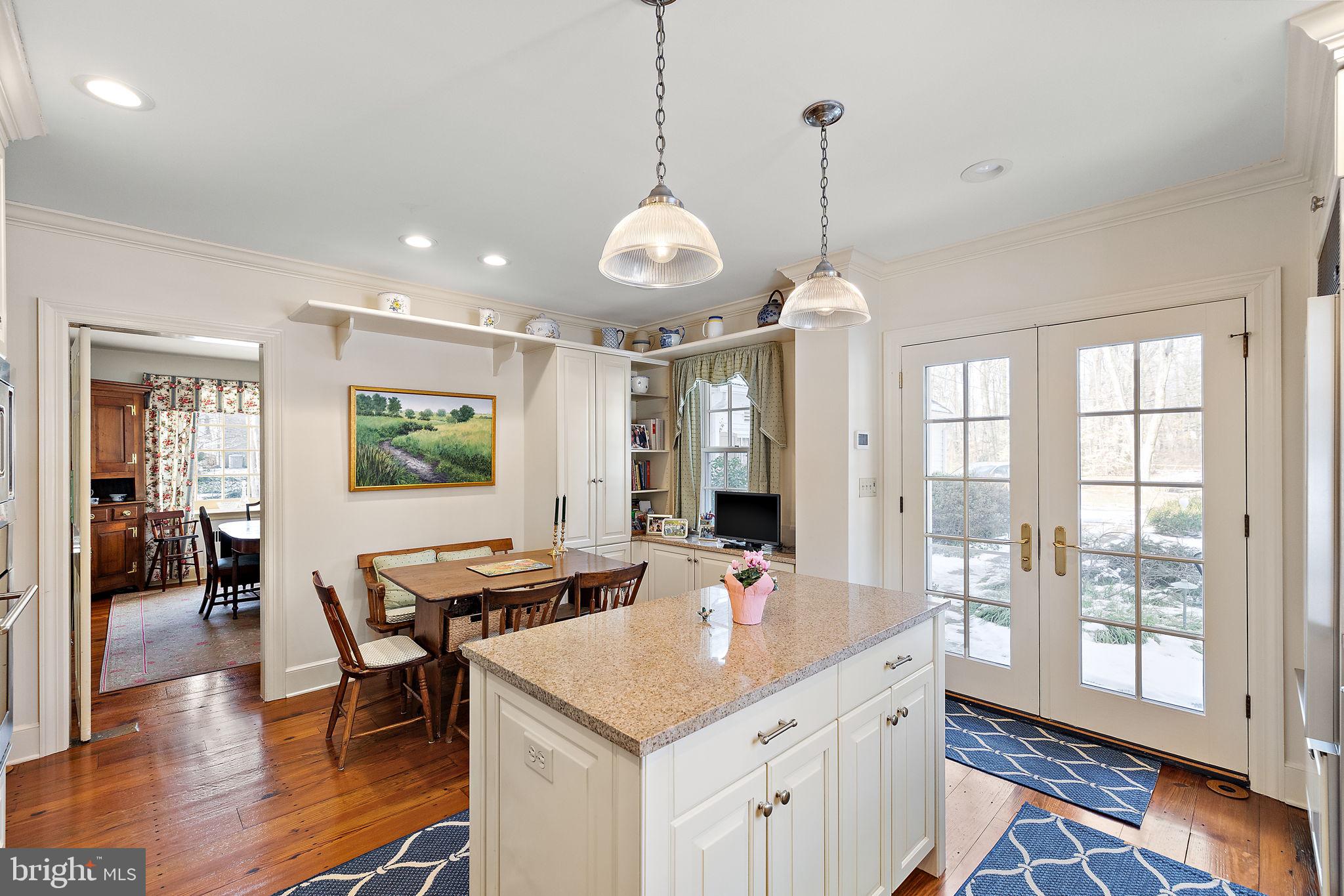 4615 Weldin Road Wilmington, DE 19803 - Photo 11 of 49 a open kitchen with stainless steel appliances granite countertop a stove top oven a dining table and chairs with wooden floor