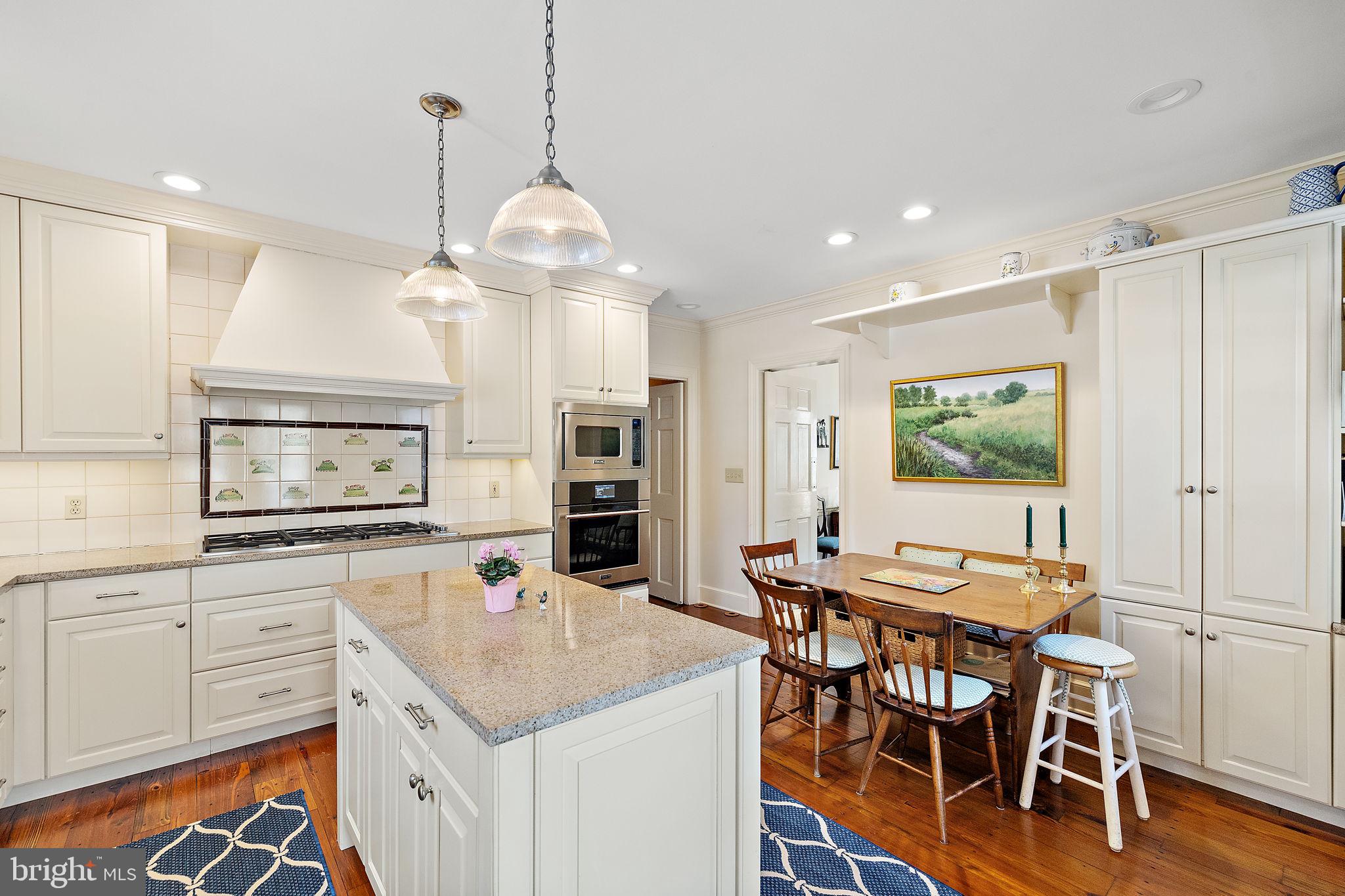 4615 Weldin Road Wilmington, DE 19803 - Photo 13 of 49 a open kitchen with stainless steel appliances granite countertop a stove a sink a dining table and chairs with wooden floor
