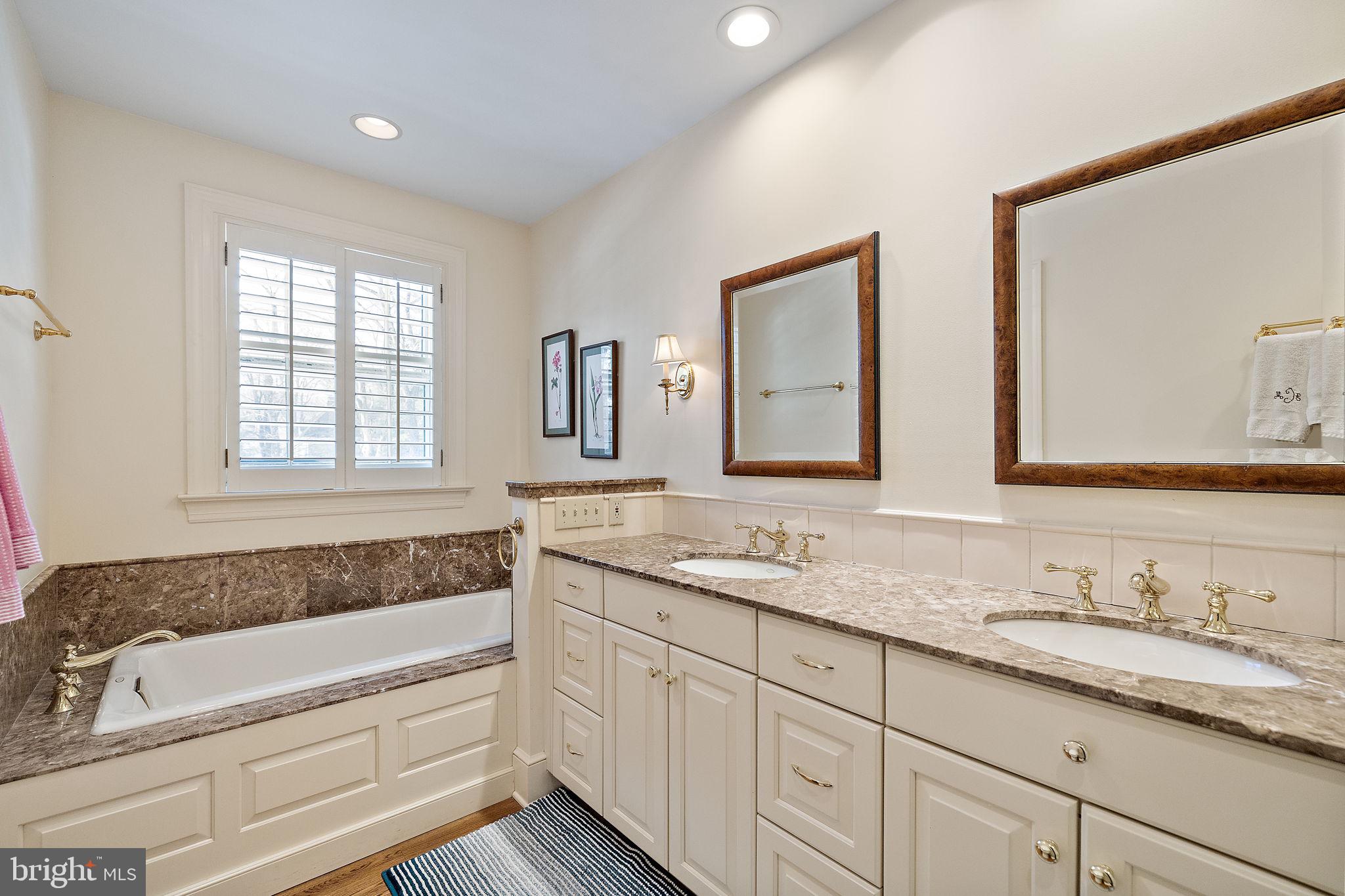 4615 Weldin Road Wilmington, DE 19803 - Photo 29 of 49 a bathroom with double vanity sinks a large mirror and a bathtub