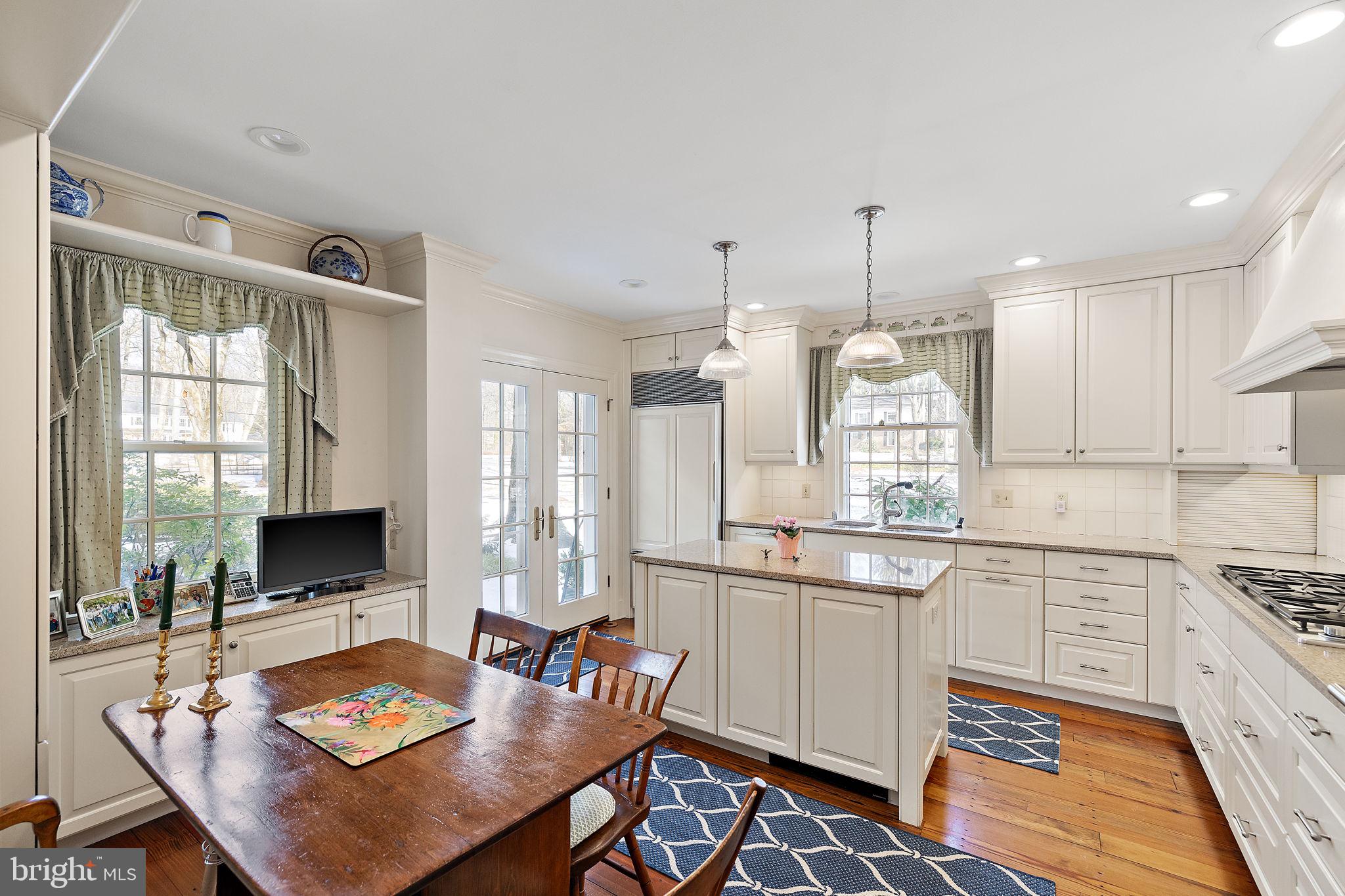 4615 Weldin Road Wilmington, DE 19803 - Photo 10 of 49 a kitchen with stainless steel appliances granite countertop a stove a sink dishwasher a dining table and chairs with wooden floor