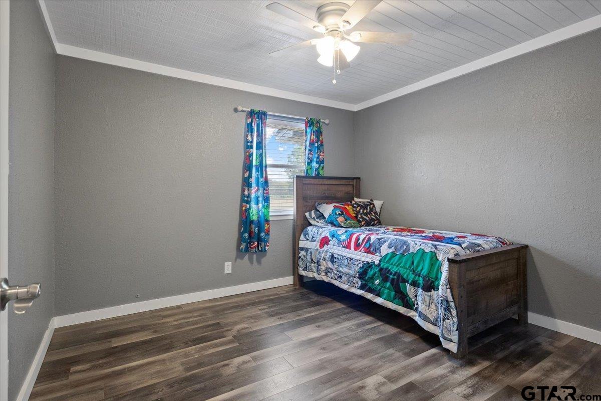 594 County Rd NE 2120 Talco, TX 75487 - Photo 17 of 36 a bedroom with a bed and a chandelier
