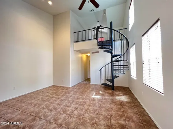 a view of an empty room with stairs and a window
